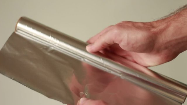 Unwrapping silver foil and cutting a slice