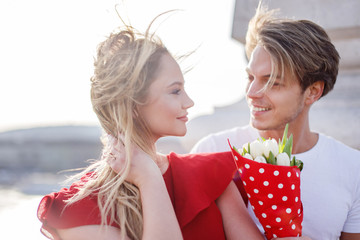 Young woman in red dress get bouquet on first date