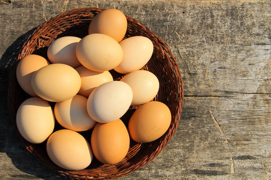 Eggs in wicker basket on wooden table