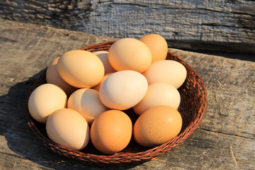 Eggs in wicker basket on wooden table