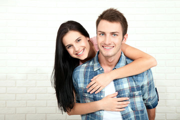 Couple in his new home. Beautiful couple hugging and looking at camera smiling sitting on sofa in living room