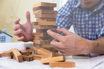 Planning, risk and strategy of project management in architect and engineer man gambling placing woon block on a tower, double exposure with crane and building under construction