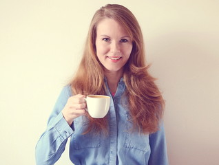 Happy beautiful young european woman smile while drinking coffee in the morning