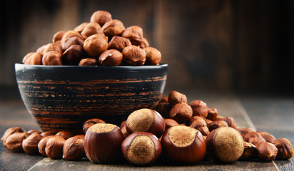 Bowl with hazelnuts on wooden table.