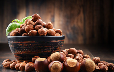 Bowl with hazelnuts on wooden table.