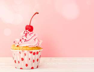 Cupcake with pink cream and cherry
