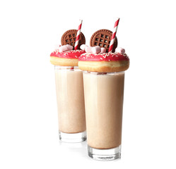 Milkshake, donuts and other sweets in glasses on white background
