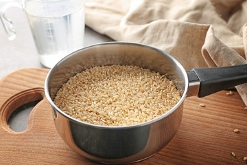 Pan with brown short grain rice on cutting board