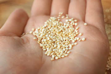 Female hand holding quinoa seeds, closeup