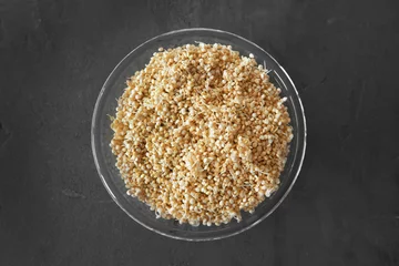 Rolgordijnen Top view of glass plate with sprouted organic white quinoa grains on dark background © Africa Studio