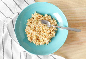 Blue plate with healthy quinoa porridge on table
