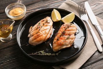 Plate with delicious chicken breasts and  lime on table