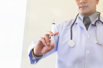 Doctor with syringe is preparing for medical injection, blur image for background