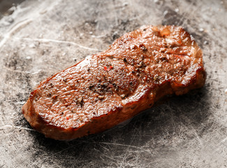 Delicious juicy steak on frying pan, closeup