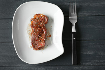 Plate with tasty steak on table