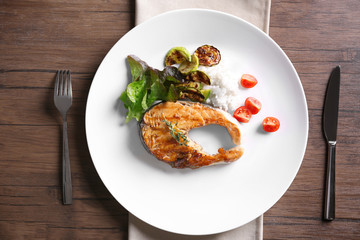 Grilled salmon steak with vegetables and rice on white plate