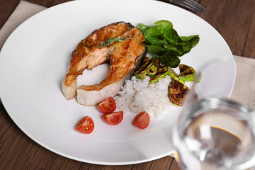 Grilled salmon steak with vegetables and rice on white plate