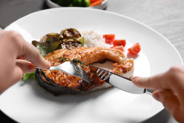 Tasting of grilled salmon steak with vegetables on white plate