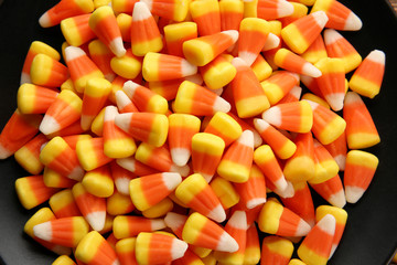 Plate with tasty Halloween candies, closeup