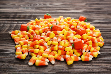 Tasty Halloween candies on wooden background, closeup