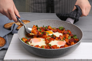 Woman holding pan with baked eggs, closeup