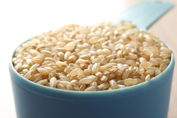 Measure scoop with brown rice closeup