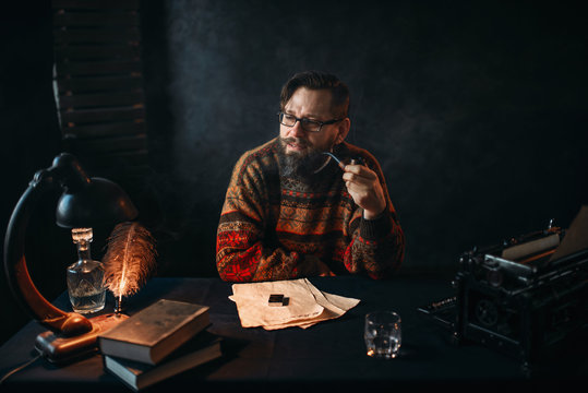 Bearded writer in glasses smoking a pipe