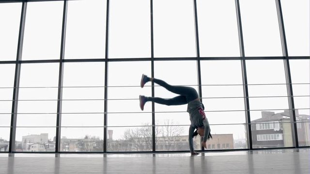 Young girl doing gymnastics on the big window background - slow motion