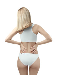 Obraz premium Young woman suffering from back pain on white background