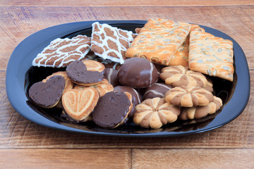 Marshmallow and cookies lying at the black plate.