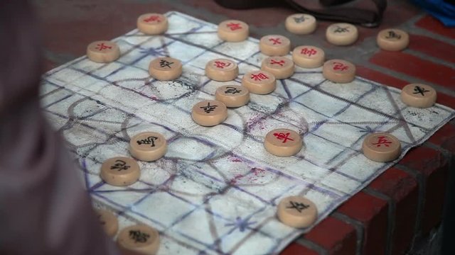 Close up shot of hands playing board game in park, Ha Noi, Vietnam