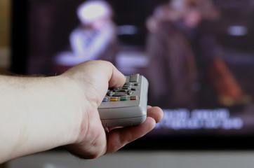 hand with a TV remote control