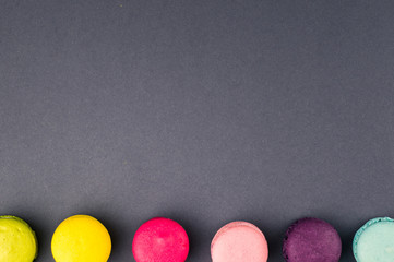 Colourful french macaroons on the grey background, Top view