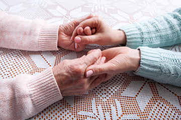 Care is at home of elderly. Senior woman with their caregiver at home. Concept of health care for elderly old people, disabled. Elderly woman. Space for text white background.
