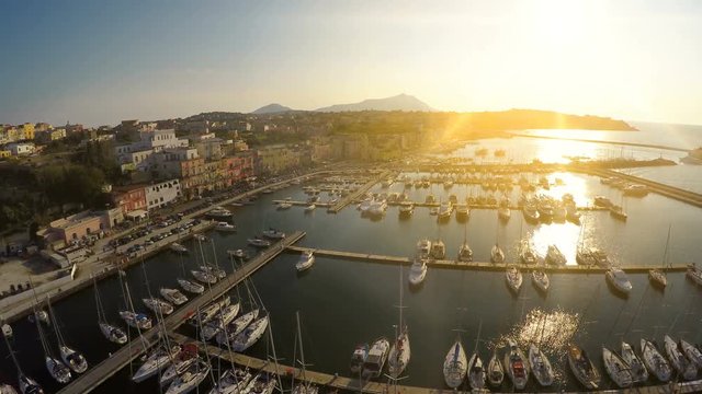 Sunrise beams penetrating Italian town with nice architecture and luxury marina