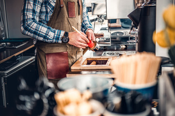 A man cleans coffee machine with a tassel.