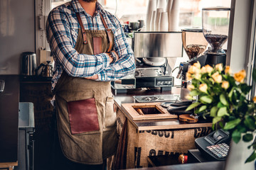 Bearded coffee seller on his workplace in a small street cafe.