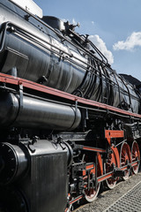 Fototapeta na wymiar Pistons, boiler and driving wheels of the historic steam locomotive.