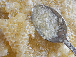 Steel spoon and honey from honeycombs