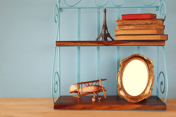Vintage shelf with old wooden plane toy, books and blank photo frame
