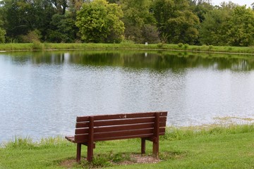 Fototapeta na wymiar The empty park bench by the lake.