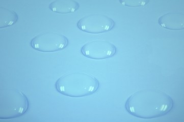 Transparent water drops on blue background.