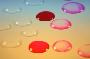 Red and transparent water drops on blue and orange background.