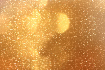 Golden abstract sparkles or glitter lights. Festive gold background.defocused circles bokeh or particles. Valentines day template
