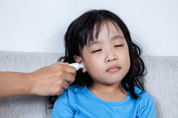 Asian Chinese little girl getting ear measurement for fever temperature