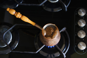 Turk with boiling coffee on gas stove