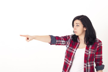Shocked young girl shows her finger sideways, pointing at something interesting