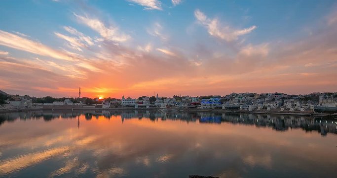 Time lapse at Pushkar, Rajasthan, India. Light fading from dusk to night. Temples, buildings and ghats reflecting on the holy water of the lake.