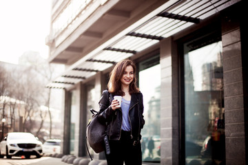 The concept of street fashion. portrait of Young girl dressed in a fashionable outfit. Posing against the window of the boutique
