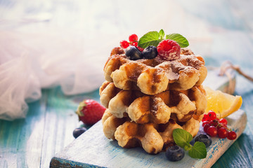Homemade Belgian waffles with berry fruit ,mint and sprinkled with sugar 